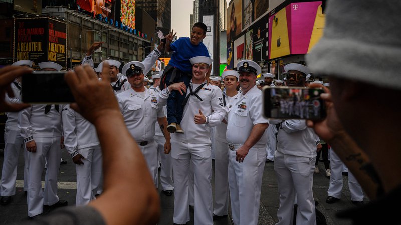 Fotografija: Otrok pozira s pripadniki ameriške vojske, zbranimi za skupinsko fotografijo na Times Squareu v okviru praznovanja Tedna flote v New Yorku. To je teden dni trajajoče praznovanje pomorskih služb, katerega namen je javnosti ponuditi priložnost, da na različnih dogodkih in predstavitvah spozna mornarje, marince in pripadnike obalne straže. Foto: Ed Jones/Afp