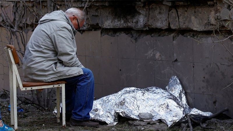 Fotografija: Gospod sedi ob truplu svoje vnukinje, ki je bila ubita v ruskem raketnem napadu na Kijev. FOTO: Valentyn Ogirenko/Reuters