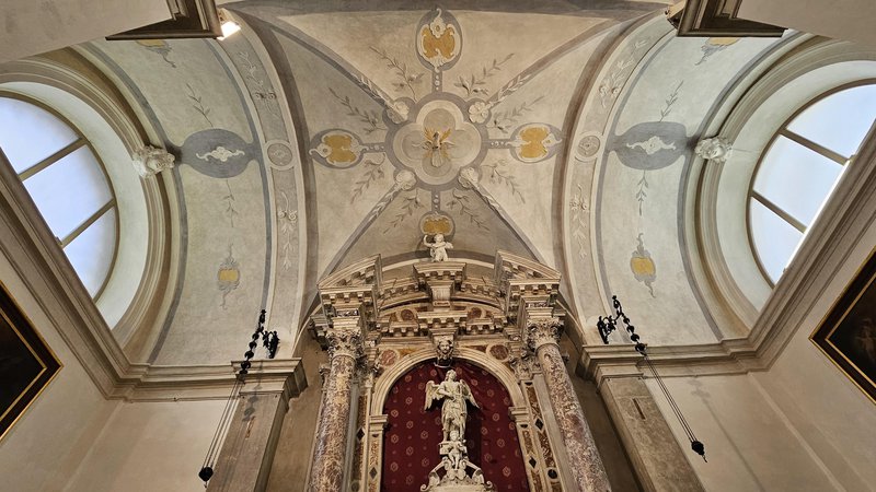 Fotografija: Oltar s kamnitim okvirjem za sliko Marija s pasom in štukatura na stropu. Foto Boris Šuligoj