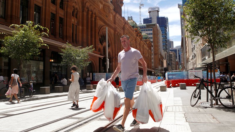Fotografija: Moški na ulici Sydneyja s plastičnimi vrečkami v roki. FOTO: Daniel Munoz/Reuters