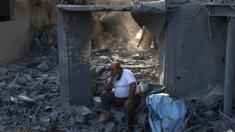 Fotografija: Palestinec sedi na ruševinah hiše, ki so jo uničili Izraelci. FOTO: Said Khatib/AFP