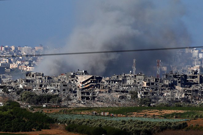 Iznad območja Gaze se danes dopoldne dviga dim, kot je videti z izza meje v Izraelu. FOTO: Evelyn Hockstein/Reuters