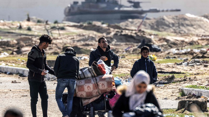 Fotografija: Palestinci bežijo iz Khan Junisa, ki so ga zavzeli izraelski tanki. FOTO: Mahmud Hams/AFP