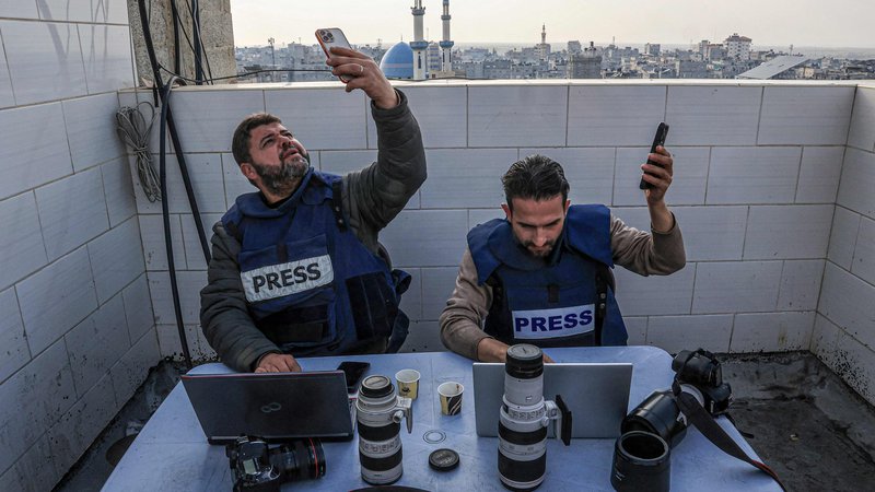 Fotografija: V Rafi na jugu Gaze se palestinski novinarji poskušajo povezati z internetom. Izpadi električne energije so v razdejani Gazi postali vsakdanjost. Vendar lahko Palestinci z vgrajenimi karticami SIM še vedno dostopajo do interneta in ostanejo v stiku s svojimi bližnjimi v tujini. Foto: Said Khatib/Afp