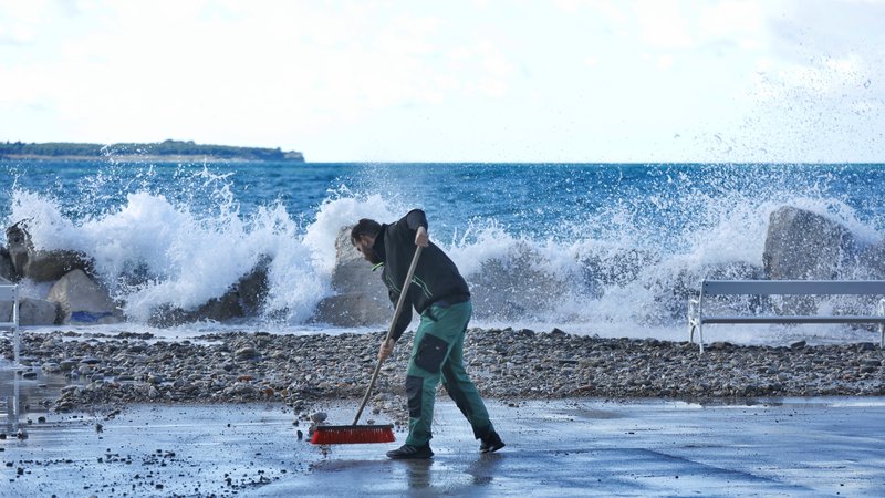 Fotografija: Čiščenje obale po poplavljanju morja v Piranu novembra lani. FOTO: Jože Suhadolnik/Delo