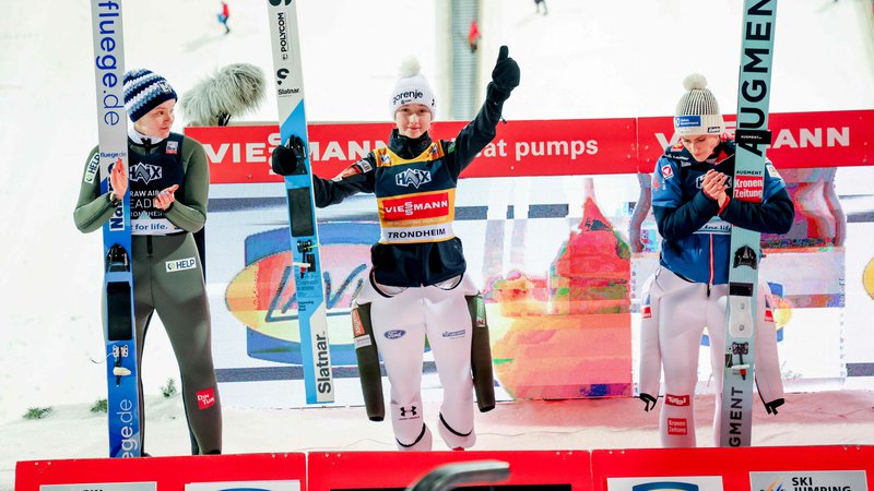 Fotografija: Niki Prevc (na sredini) sta družbo na zmagovalnem odru delali drugouvrščena Norvežanka Eirin Maria Kvandal (levo) in tretjeuvrščena Avstrijka Eva Pinkelnig. FOTO: Geir Olsen/AFP