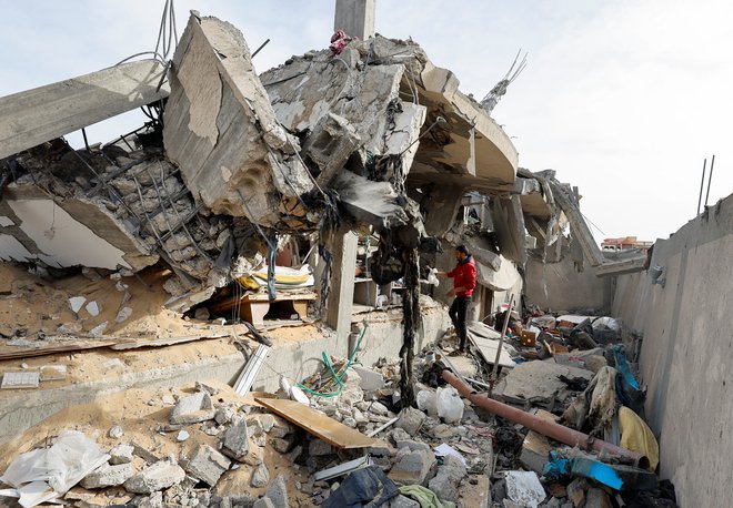 Palestinec pregleduje kraj napada izraelske vojske na hišo. FOTO: Mohammed Salem/Reuters