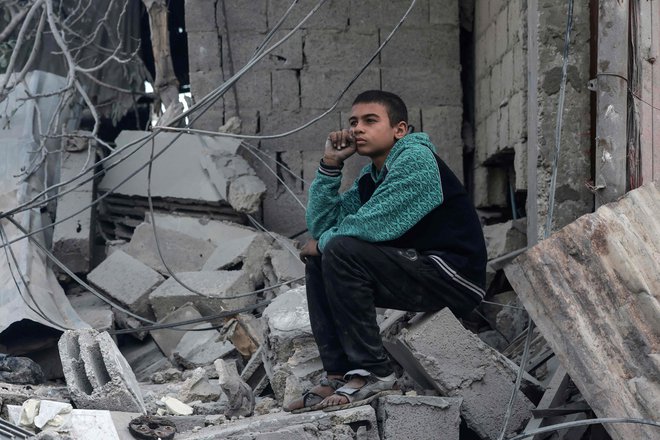 Palestinski deček na ruševinah stavbe v Gazi. FOTO: Mohammed Abed/Afp
