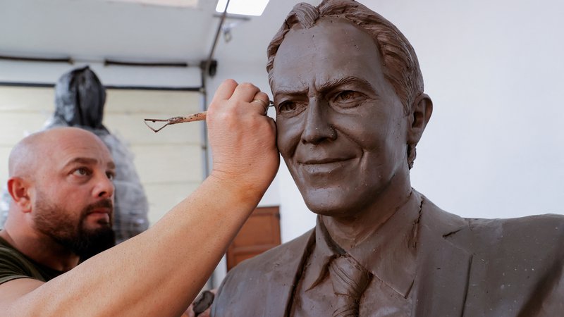 Fotografija: Agon Qosa končuje kip s podobo nekdanjega britanskega predsednika vlade Tonyja Blaira. FOTO: Valdrin Xhemaj/Reuters