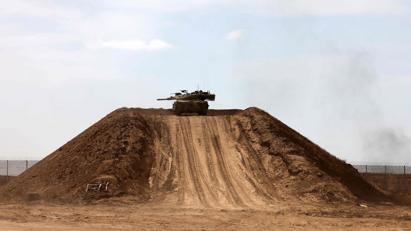 Fotografija: Izraelski tank na peščeni gori v Gazi. FOTO: Menahem Kahan/AFP