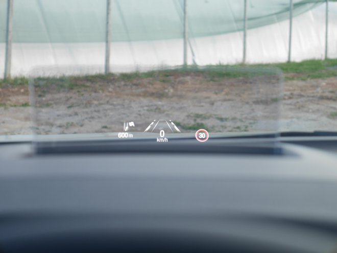 Prosojni zaslon vozniku bolj pred oči postavi številne koristne informacije, še lepše pa bi bilo, če bi se namesto na plastično stekelce vse skupaj zarisalo neposredno na vetrobran. Foto Boštjan Okorn
