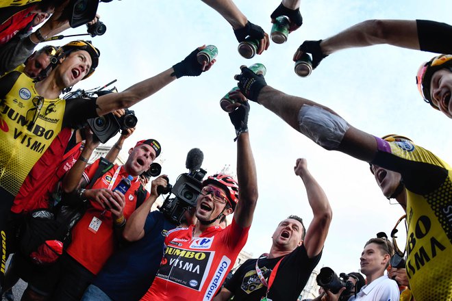 Kolesarji ekipe Jumbo Visma so s Primožem Rogličem nazdravili k prvi zmagi na tritedenski dirki. FOTO: AFP