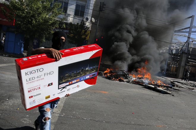 Nemire v Čilu mnogi izkoriščajo za plenjenje trgovin. Na posnetku včerajšnje dogajanje v Valparaisu. FOTO: Javier Torres/AFP