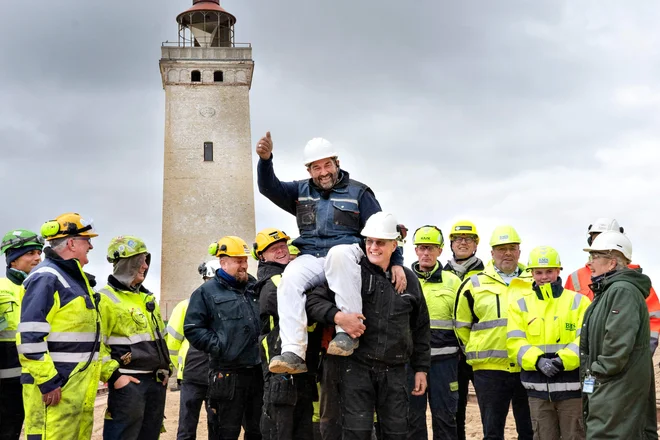 Gradbeniki so včeraj tako proslavili uspešni prevoz svetilnika. FOTO: Hans Ravn/AFP