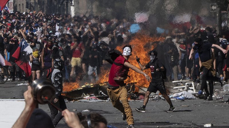Fotografija: Protivladni protesti, ki se v Čilu nadaljujejo, so doslej zahtevali najmanj 15 žrtev. Predsednik Sebastian Pinera je zato v televizijskem nagovoru opozicijo pozval k pogovorom in predlagal družbeni dogovor za izpolnitev zahtev protestnikov. V govoru v predsedniški palači La Moneda je Pinera opozicijo pozval k sodelovanju z vlado pri iskanju rešitev za socialno krizo v državi. vlada pripravlja načrt obnove. Cilji so med drugim zvišanje pokojnin, znižanje cen zdravil in regulacija cen električne energije. FOTO: Pedro Ugarte/AFP