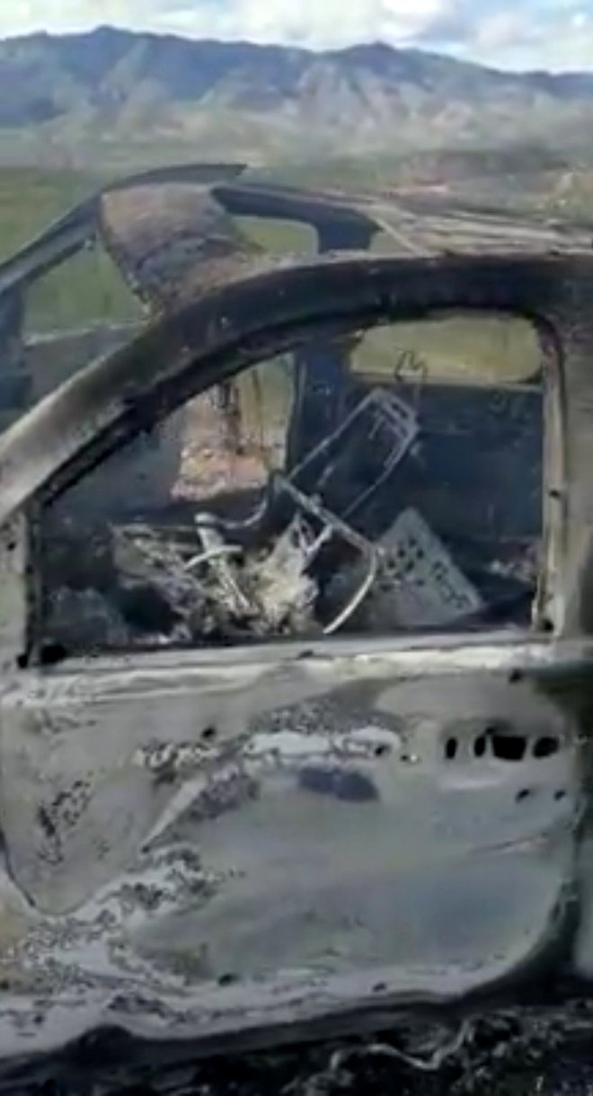 Požgani in prestreljeni avtomobil ene od napadenih družin. FOTO: Reuters