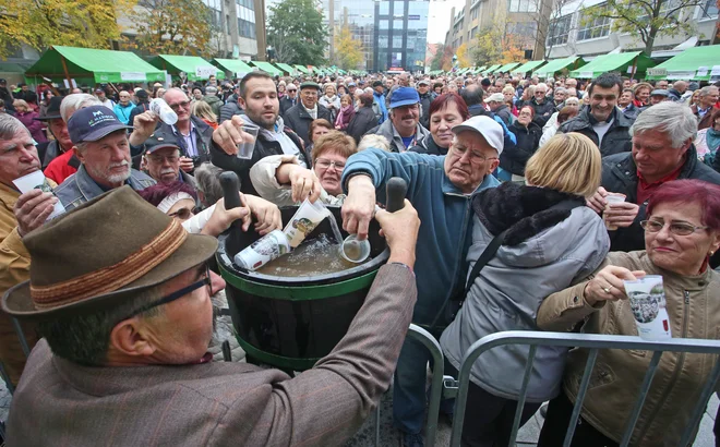 Martinovanje na Trgu Leona tuklja, Alojz Jenu - Slavek, outar in brač iz Malečnika deli meanico vin iz okolica Maribora obiskovalcem Martinovanja, 11.11.2017, Maribor [martinovanje, alojz jenu, vino]