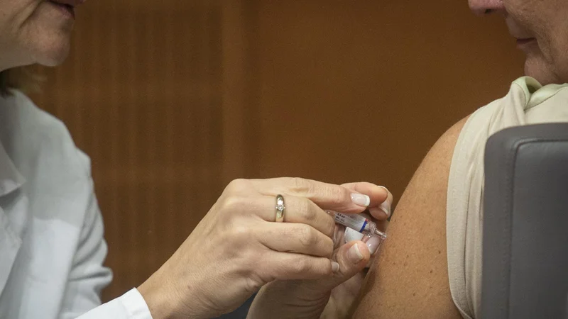 Fotografija: »Za cepljenje proti gripi je bila vrsta v zdravstvenem domu tako dolga in gneča tako velika, da je bil zrak na hodniku zadušljiv, zaradi česar so bili potrpežljivi starčki v vrsti, izpostavljeni dodatni neprijetnosti čakanja. Vsekakor nisem bil osamljen primer, ki se ni uspel naročiti za cepljenje pri svojem družinskem zdravniku, sicer ne bi bilo v vrsti za cepljenje, ki se je začelo ob 13. uri že ob 13.30 več kot 500 ljudi,« je neprijetno izkušnjo opisal Stanko Štrajn. FOTO: Voranc Vogel/Delo