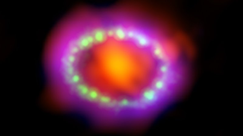 Fotografija: Fotografija ostanka supernove 1987A je kombinacija opazovanj teleskopov Alma (rdeče), Hubble (zeleno) in Chandra (modro). 
FOTO: NASA, ESA, and A. Angelich (NRAO/AUI/NSF) 