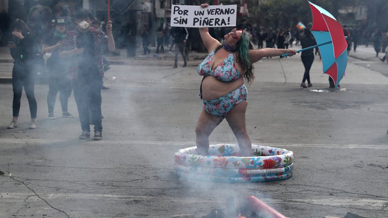 Fotografija: Ženska pleše na ulici glavnega mesta Čila, kjer že več tednov potekajo protivladne demonstracije. FOTO: Ivan Alvarado/Reuters