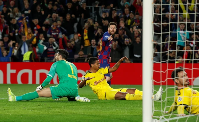 Lionel Messi je na tla položil tekmece za svoj 114. gol v ligi prvakov. FOTO: Reuters