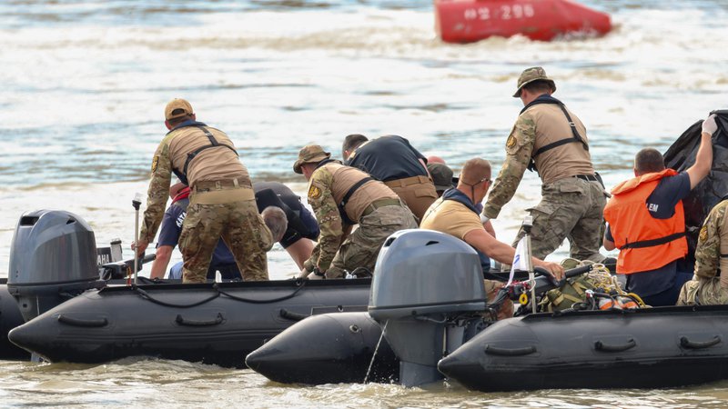 Fotografija: Madžarski in korejski reševalci po nesreči križarke na Donavi. FOTO: Ferenc Isza/AFP