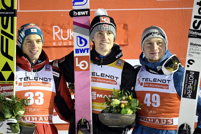 Philipp Aschenwald (levo), Daniel Andre Tande (v sredini) in Anže Lanišek na odru za zmagovalce v Ruki. FOTO: Reuters
