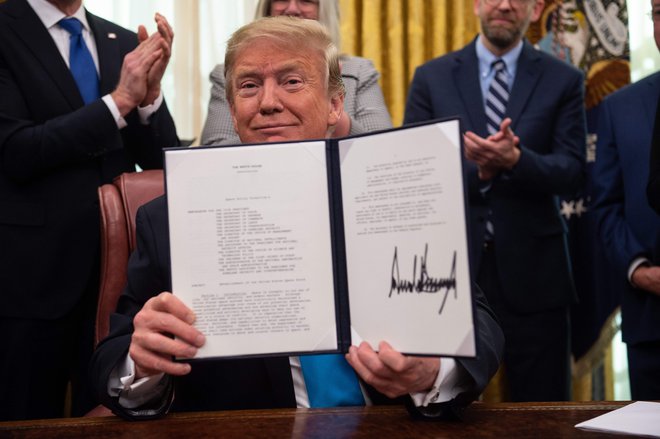 Predsednik Trump razkazuje svoj podpis na ukazu za ustanovitev vesoljskih sil ameriške vojske. Foto Nicholas Kamm Afp