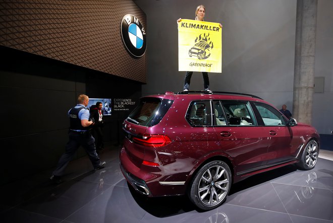 Aktivsti Greenpeacea je takole protestiral na enem BMW-jevih športnih terencev, ki so razstavljeni na salonu v Frankfurtu. FOTO: Reuters
