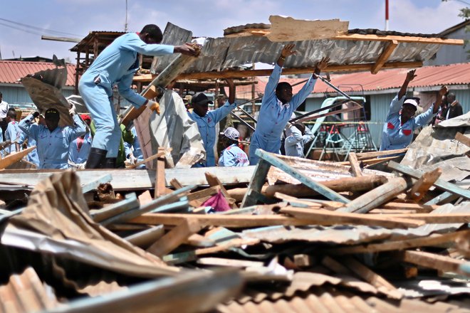Televizijske postaje so pokazale posnetke reševalcev, ki so v šoli premetavali kovinske plošče in betonske plošče ter v reševalno vozilo nosili bele torbe. FOTO: Tony Karumba/AFP