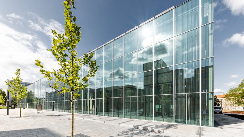 Fotografija: V fasadi novega Bauhausovega muzeja v Dessauu se zrcalita mesto in park. FOTO: Hartmut Boesener