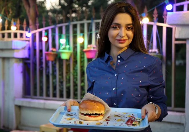 V svoji prikolici v Erbilu Zilan Servud ne pripravlja kakšnih lokalnih specialitet, ampak &raquo;globalno&laquo; hitro prehrano &ndash; hamburgerje, ocvrt krompir in čebulne obročke. FOTO: AFP