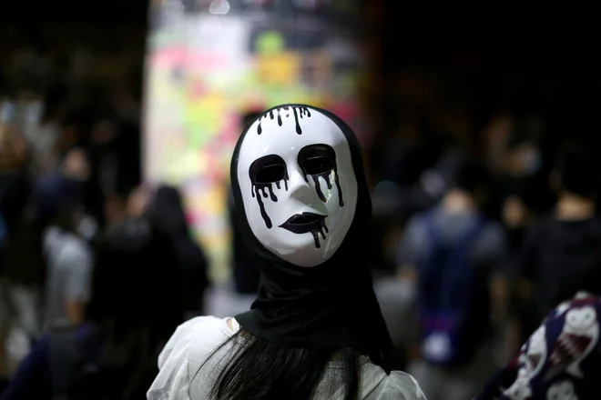 Za kršenje zakona o prepovedi nošenja mask je lahko vsakdo obsojen na zaporno kazen do enega leta ali denarno kazen v znesku 25.000 hongkonških dolarjev (3000 ameriških dolarjev). FOTO: Athit Perawongmetha/Reuters