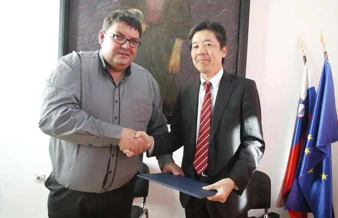 Tomaž Vencelj in Hidaki Hanami ob podpisu pogodbe med občino Idrija in japonskim vlagateljem Hitachi. FOTO: Roman Šipić/Delo