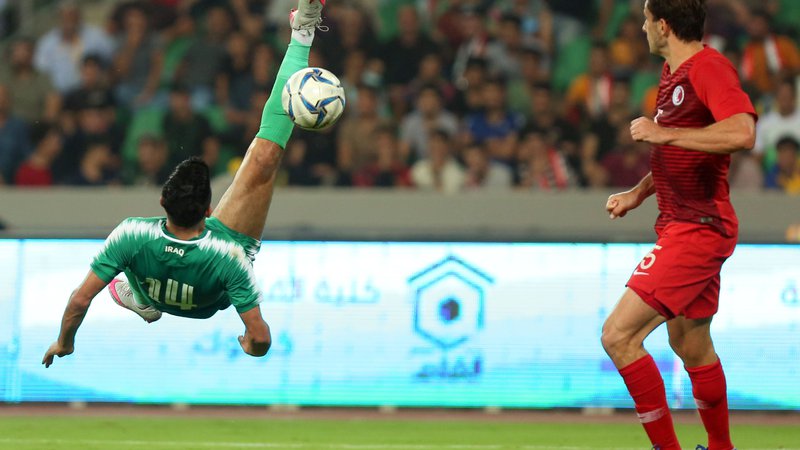 Fotografija: Iračan Amjad Attwan je z atraktivnim poskusom želel zabiti gol. Ni bil uspešen, a je Irak vseeno dosegel prvo kvalifikacijsko zmago pred domačimi navijači v Basri. FOTO: AFP