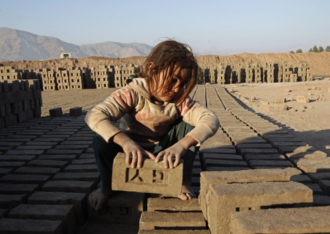 Afganistanska deklica na delu. FOTO: Parwiz Parwiz/Reuters