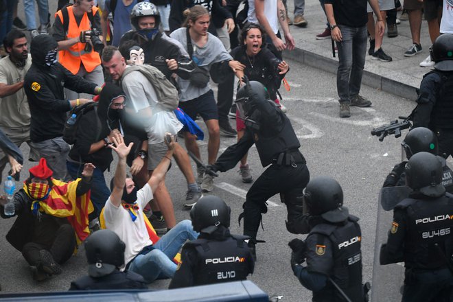 Španske in druge tuje medije so preplavile fotografije nasilja med policisti in udeleženci shoda na barcelonskem letališču El Prat. Policisti so zoper protestnike uporabili pendreke. FOTO: Lluis Gene/AFP