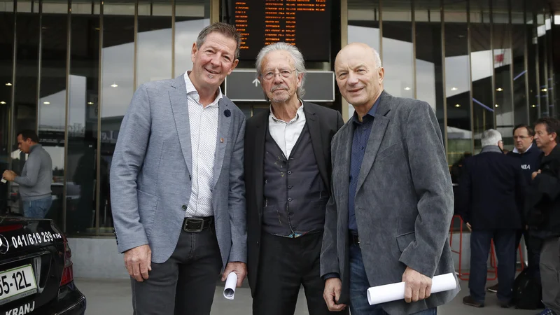 Fotografija: Peter Handke (na sredini) je včeraj preko Brnika pripotoval v rojstno okolje. FOTO: Leon Vidic/Delo