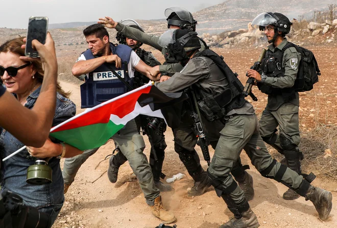 Izraelski mejni policisti napadajo fotoreporterja med demonstracijami proti izraelski gradnji v bližini palestinske vasice Turmus Ayya, severno od Ramallaha na okupiranem Zahodnem bregu. FOTO: Jaafar Ashtiyeh/AFP