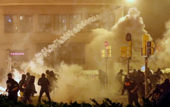 Včeraj okoli 18. ure pred poslopjem španske policije v Barceloni izbruhnili spopadi med protestniki in policisti. FOTO: Jon Nazca/Reuters
