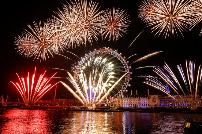 Znamenitost britanske prestolnice London Eye obsijana z ognjemetom. FOTO: Henry Nicholls/Reuters