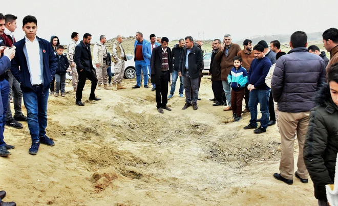 Iraški Kurdi ob kraterju, ki ga je poovzročil iranski izstrelek. Foto - Afp