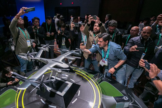 Obiskovalci si ogledujejo maketo modela S-A1, ki je nekakšen električni dron za prevoz potnikov, predstavil ga je korejski Hyundai, razvija pa ga v sodelovanju s podjetjem za prevoz Uber.<br />
FOTO: AFP