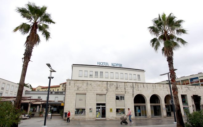 Kot hotel Triglav so ga odprli na silvestrovo 1952. Skupaj z novo tržnico ter novo avtobusno in ladijsko čakalnico ob starem pristanišču je zaživel kot novo urbano središče povojnega Kopra. Fotografiji Roman Šipić