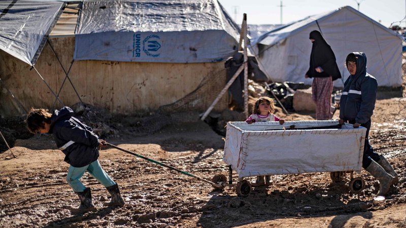 Fotografija: Dečki se igrajo v blatu v kurdskem taboru al-Hol na severovzhodu Sirije, kjer se nahajajo družine tujih borcev Islamske države. Kurdske oblasti so opozorile, da bo glasovanje OZN za razrešitev vhodne točke Yaroubiyja za čezmejno pomoč okrnilo vsaj polovico odgovora na zdravstveno varstvo na območju, ki ga pustošijo bitke in bo posledično preprečilo dostop do 60 odstotkov zdravstvene pomoči do prenaseljenega puščavskega tabora, kjer je več deset tisoč civilistov. FOTO: Delil Souleiman/Afp
 