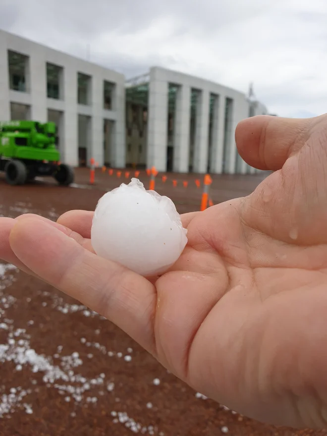 Takšna zrna toče so danes padala pred parlamentom v Canberri. FOTO: Handout AFP