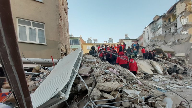 Fotografija: Mediji so objavili posnetke, na katerih je videti, kako več deset reševalcev v tišini išče preživele na vrhu večnadstropne stavbe, ki se je zrušila. FOTO: Ali Haydar Gozlu/AFP