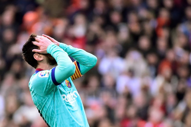Lionel Messi se je med tekmo v Valencii večkrat nemočno prijel za glavo, saj Barceloni nikakor ni steklo po načrtu. FOTO: AFP