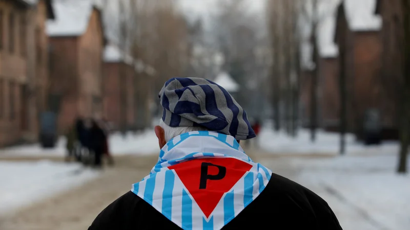 Fotografija: Eden izmed preživelih taboriščnikov, ki so ob lanski 74. obletnici obiskali območje nekdanje tovarne smrti v Auschwitzu. FOTO: Reuters