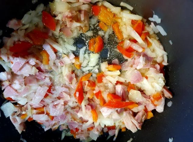 Na vročem olju prepražimo čebulo, sesekljano papriko, slanino, paradižnik in sesekljan česen. Foto: Tanja Drinovec